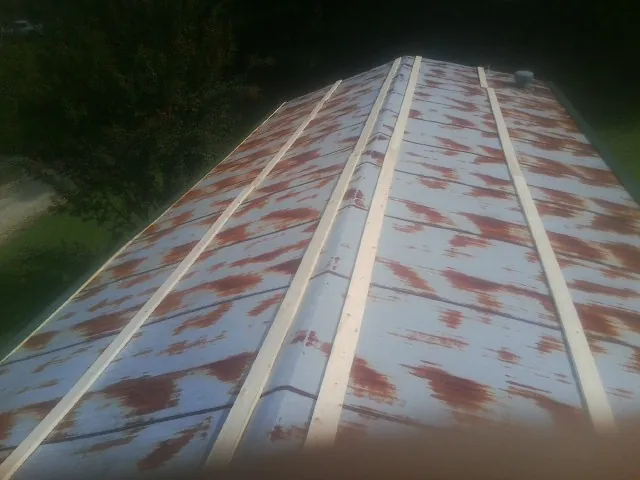 Rusted metal roof panels with new wood purlins before replacement — Storm Damage Roof Repair in Webster Springs by Roofing Brothers
