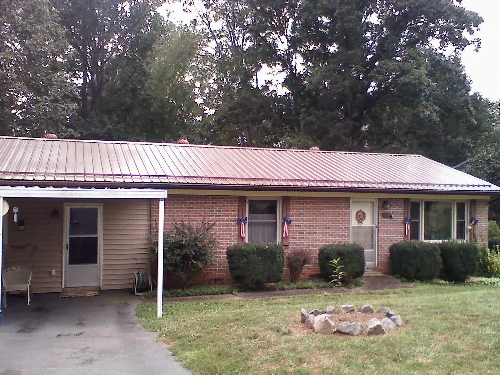 Bronze metal roof and carport on a brick ranch home — Roof Repair work by our crew in Webster Springs