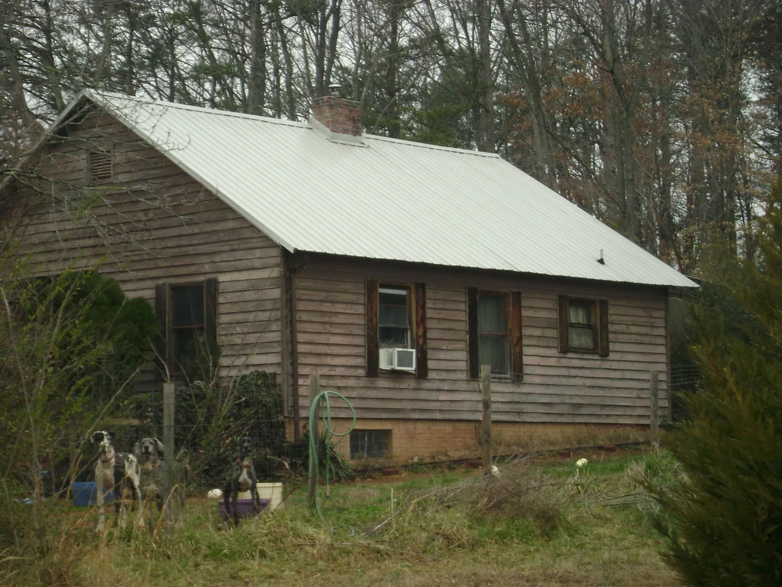 White metal roof on an old wood sided farmhouse, from a Metal Roof Installation job in Webster Springs